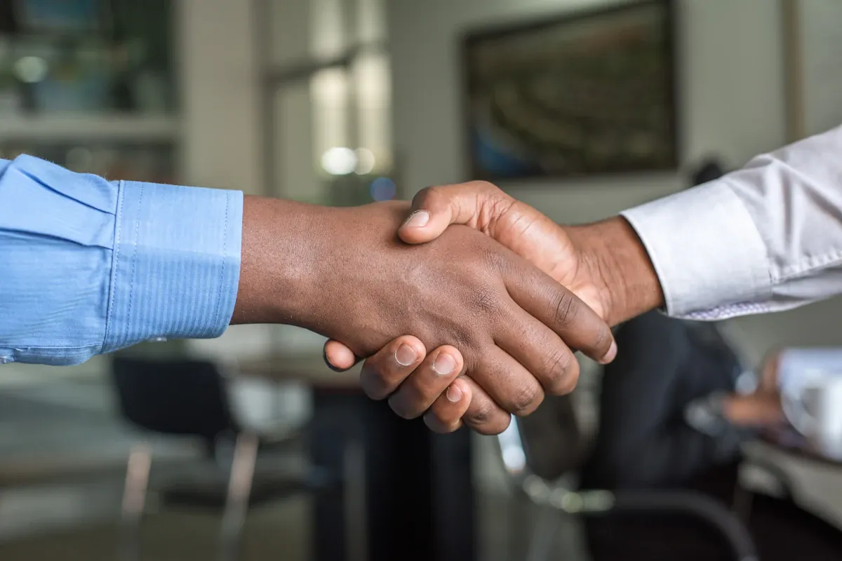 Two people shaking hands in a calm, respectful greeting